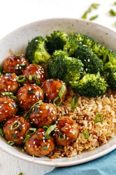 a white bowl filled with meatballs and broccoli on top of brown rice