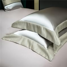 two pillows sitting next to each other on top of a bed