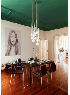 a dining room table with chairs and a painting on the wall