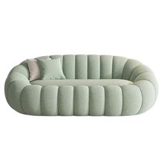 an oval shaped couch with pillows on the top and bottom, sitting in front of a white background