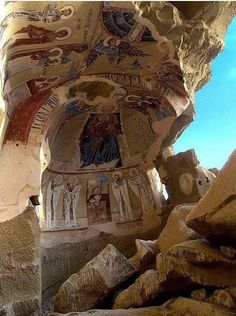 the interior of an ancient building with paintings on it's walls and stone pillars