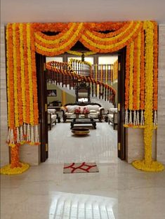 an entrance decorated with orange and yellow flowers for a wedding ceremony or reception at the same time