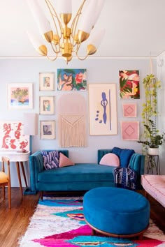 a living room with blue couches and pictures on the wall above them, along with colorful rugs