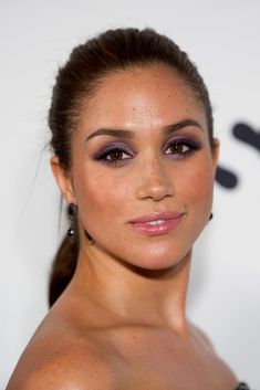 a close up of a woman with purple eyeshadow