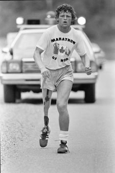 a man is running down the street in shorts