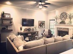 a living room filled with furniture and a flat screen tv mounted on the wall above a fire place