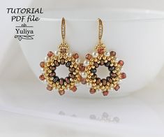 a pair of beaded earrings with pearls and beads hanging from it's sides