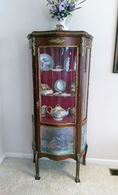 an ornate china cabinet with flowers on top