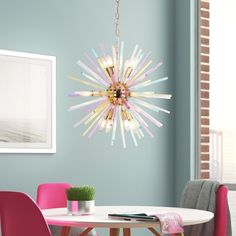 a dining room table with pink chairs and a chandelier hanging from the ceiling