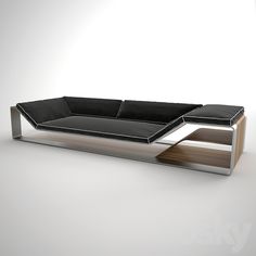 a black and silver couch sitting on top of a white floor next to a wooden table