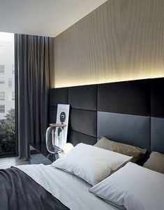 a bed with white pillows and black headboard next to a large window overlooking the city