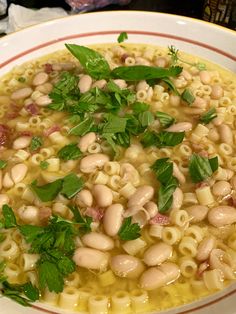 a white bowl filled with pasta and greens