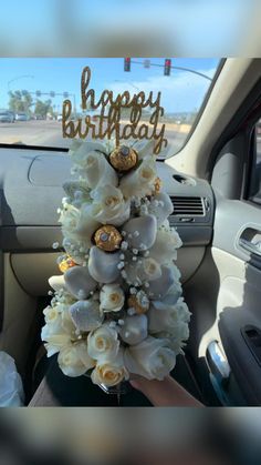 a car decorated with white flowers and gold glitters for a happy birthday card in the passenger seat