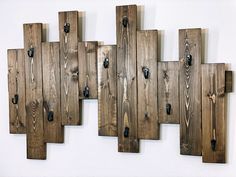 several pieces of wood are mounted to the wall with black knobs and handles on them