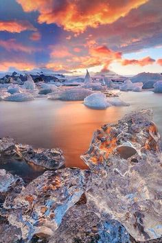 the sun is setting over some icebergs in the water, and it looks like they are melting