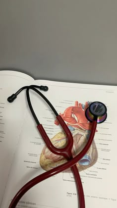 a book with a stethoscope on top of it next to a heart