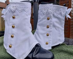 I've made some white velvet spats, ideal for your Victorian Steampunk Wedding. The fabric is white cotton velvet and the spats are fully lined in white poly cotton. They fasten with small brass buttons on the outer sides & are edged with white satin binding. White guipure lace trims the tops of these beauties.  An elaborate white satin bow featuring and ornate gold an enamel button trims the back of the spats. An elastic strap fits under the sole of the boot. They are approx. 8 inches long & mea Boot Covers, Boot Spats, 1800s Shoes Victorian Boots, Victorian Leg Warmers, White Victorian Boots, Victorian Button Boots, Victorian White Underbust Corset, Victorian Steampunk Wedding, History Bounding