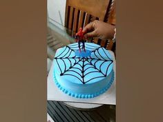 a spider web cake is being cut by someone