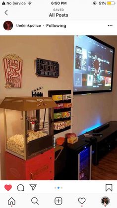 a tv mounted to the side of a wall next to a shelf filled with popcorn