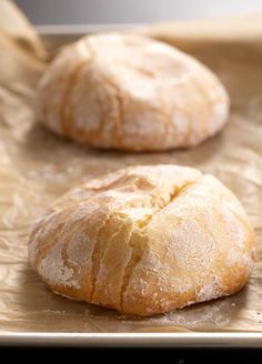 two loaves of bread sitting on top of a baking sheet