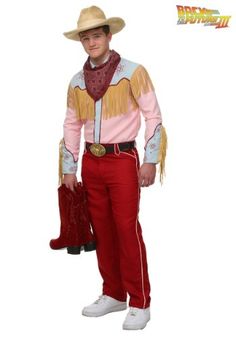 a man in a cowboy outfit is holding a red bag and posing for the camera