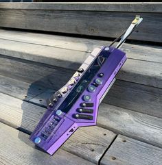 a purple electronic device sitting on top of wooden steps