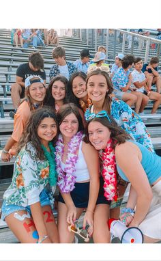 a group of young women standing next to each other in front of bleachers