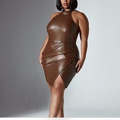 a woman in a brown leather dress posing for the camera with her hands on her hips