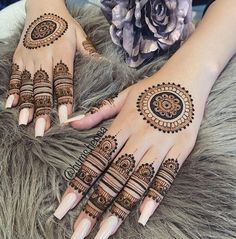 two hands with henna tattoos on them