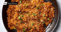 a pan filled with rice and vegetables on top of a table