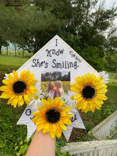 a graduation cap with sunflowers and a photo on it that says i know she's smiling