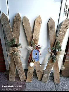 three wooden letters decorated with christmas decorations and bows are hanging on the wall next to a door