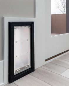 an empty refrigerator in the corner of a room next to a wall with a window