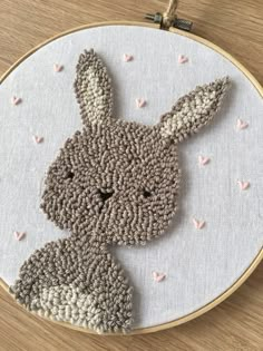 a close up of a embroidery on a hoop with a bunny face in the center