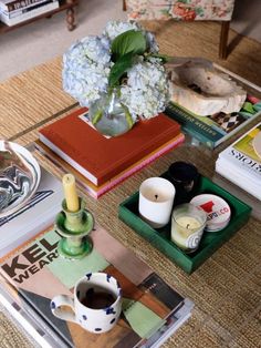 a coffee table topped with books and candles