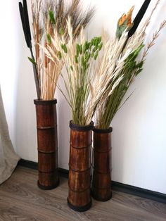 two vases with plants in them sitting on the floor