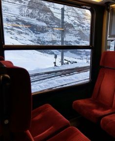 a train car with two red seats facing the window