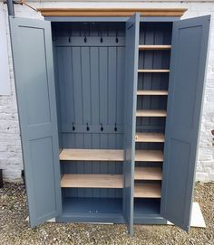 an open storage cabinet with shelves and hooks