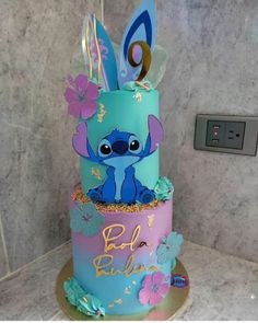 a blue and pink birthday cake with an image of stitcher from the disney movie