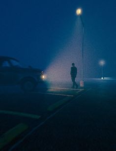 a man standing in the middle of a parking lot at night with his head down