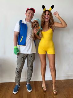 a man and woman in costumes posing for the camera with a dog on their lap