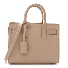 This is an authentic SAINT LAURENT Smooth Calfskin Nano Sac de Jour in Dark Beige. This chic mini tote is crafted of smooth calfskin leather in beige. The bag features gusseted side panels, rolled leather top handles, and an optional, adjustable crossbody strap with gold hardware. The top is open to a matching leather interior. Dark Beige, Mini Tote, Christmas Wishlist, Side Panels, Leather Interior, Leather Top, Crossbody Strap, Panel Siding, Gold Hardware