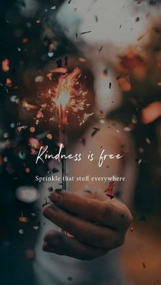 someone holding a sparkler in their hand with the words kindness is free on it