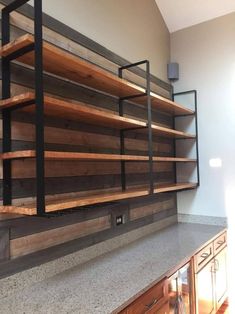 a kitchen counter with wooden shelves on the side and metal bars at the top,