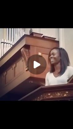 a woman standing at the top of a church pulpit with an organ in the background