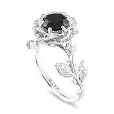 a black diamond engagement ring with leaves on the band and an oval center stone in the middle