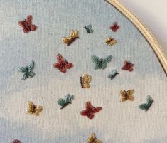 a close up of a cross stitch pattern with many small butterflies on the back of it