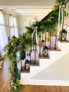 a staircase decorated with christmas greenery and lanterns for the holiday season is pictured in this image