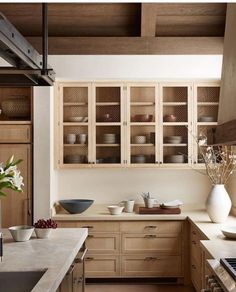 a kitchen filled with lots of wooden cabinets and counter top space next to a window