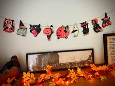 there are many decorations hanging on the wall next to a framed photo and pumpkins